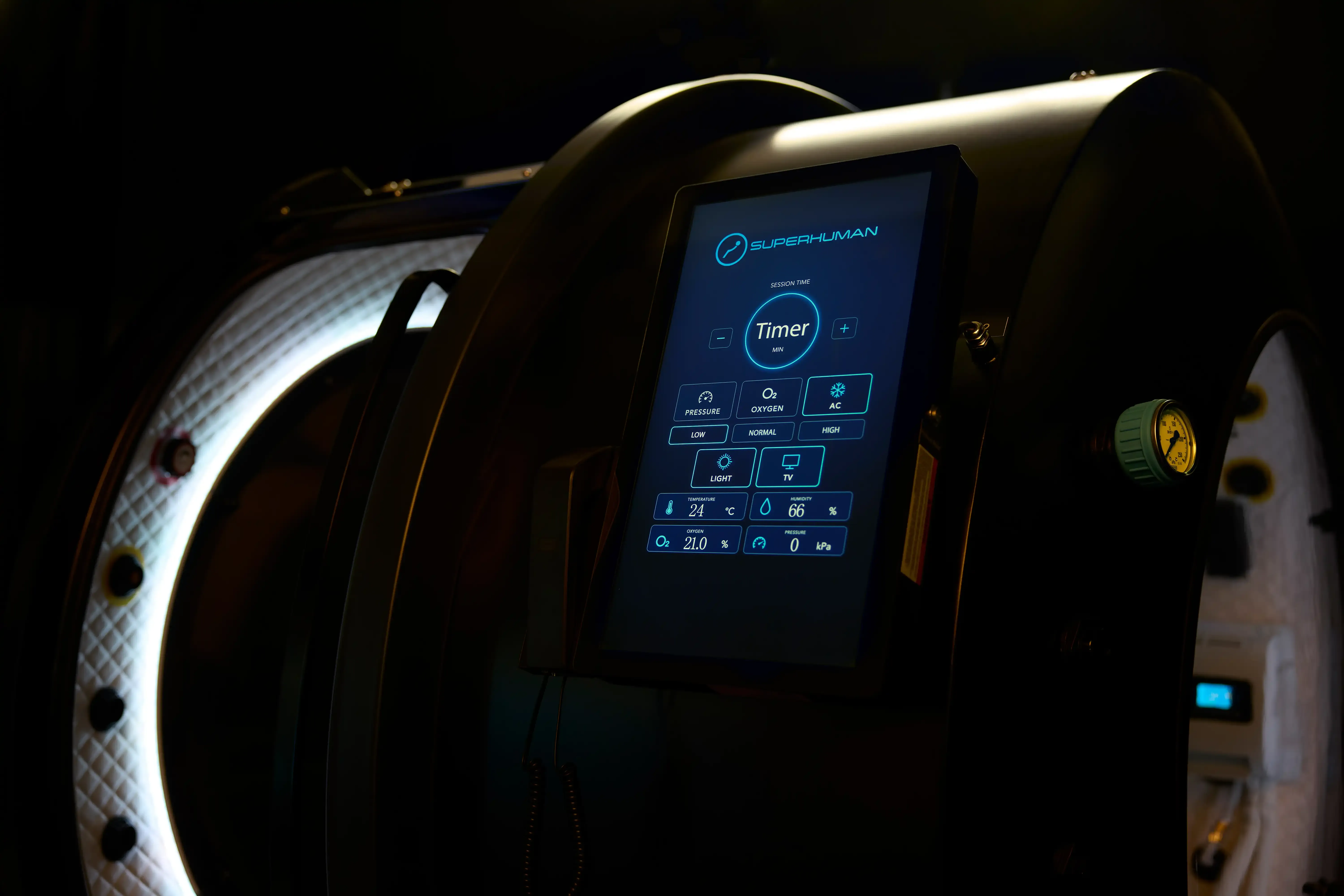 The Superhuman X control panel showing session timer, pressure, oxygen and climate controls beside the open door